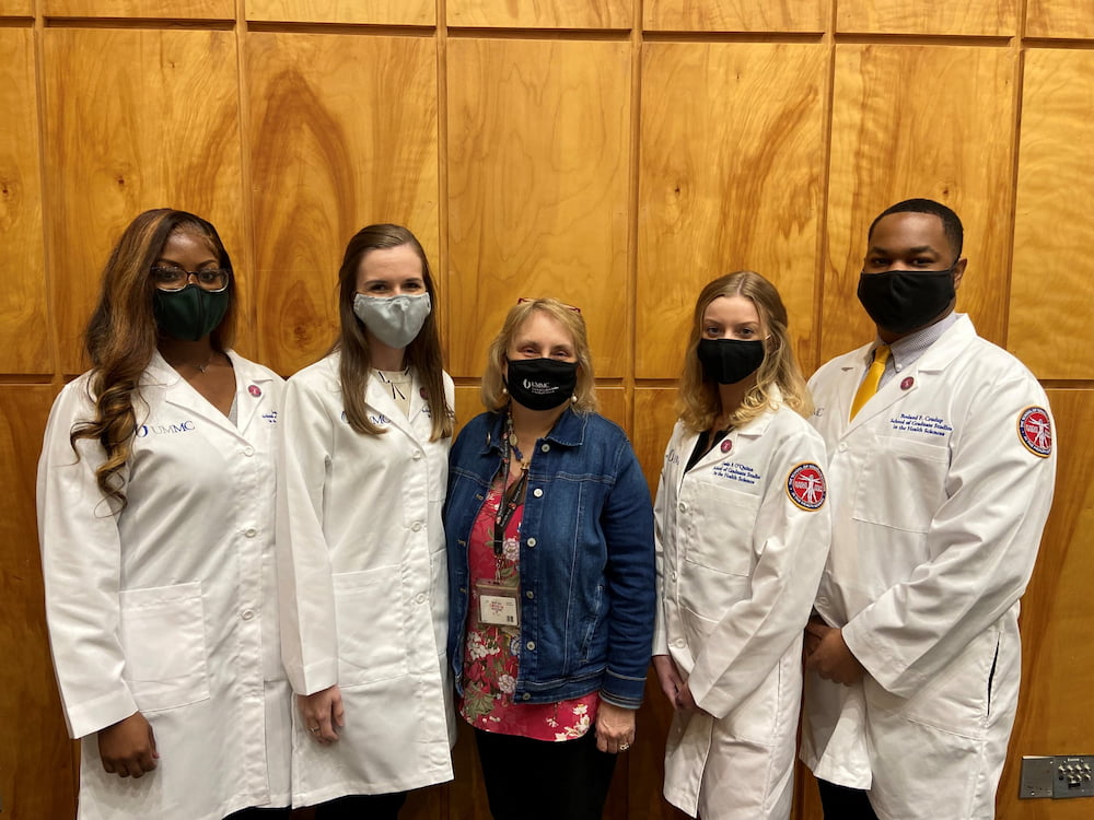 Dr. Barbara Alexander standing with four grad students